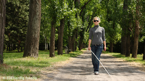 Blinde Frau mit Blindenstock beim Spaziergang